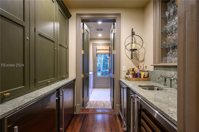 bar with wine cooler, sink, light stone counters, and dark hardwood / wood-style floors