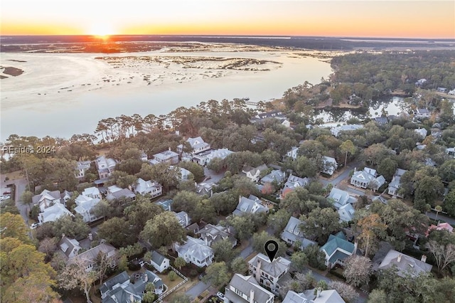 aerial view at dusk featuring a water view