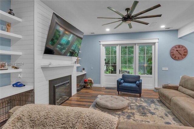 living room featuring ceiling fan and dark hardwood / wood-style flooring