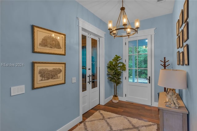 entryway with dark hardwood / wood-style floors and a chandelier