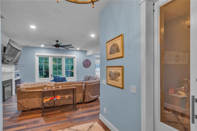 living room with dark wood-type flooring and ceiling fan