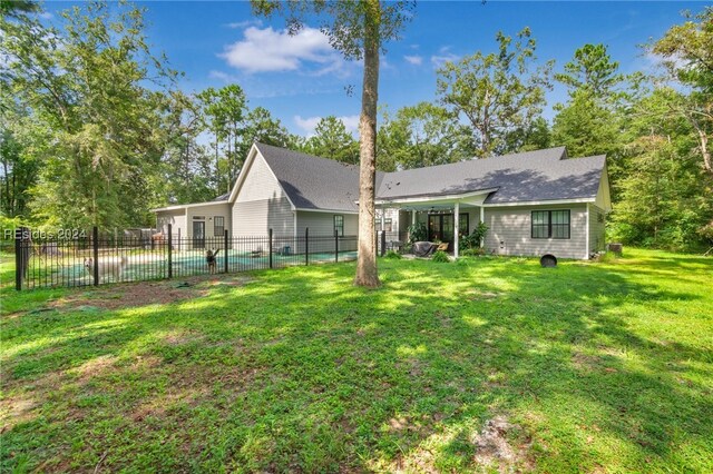 view of front of home featuring a fenced in pool and a front lawn