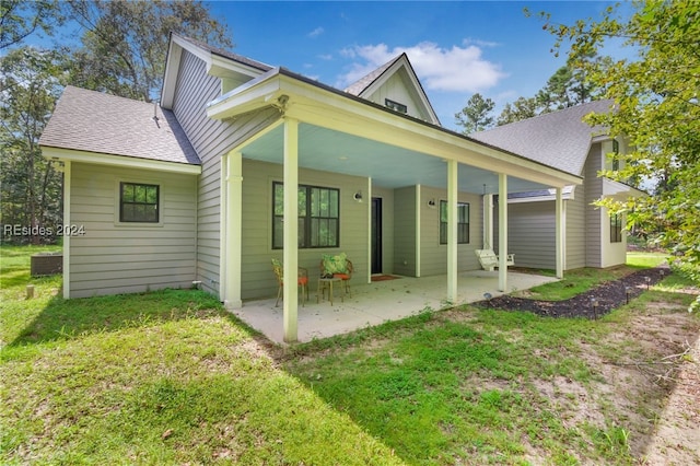 rear view of property featuring a patio and a lawn