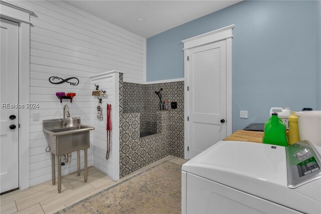 bathroom featuring tile walls, wood-type flooring, and washer and dryer