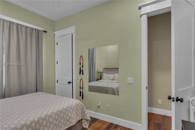 bedroom with dark hardwood / wood-style flooring