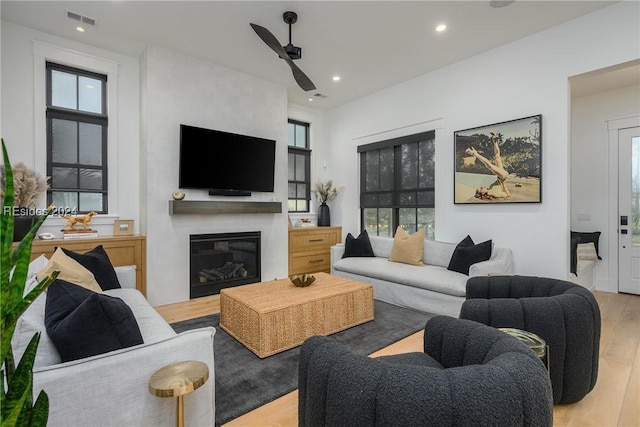 living room with plenty of natural light, a fireplace, and light wood-type flooring