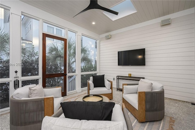 sunroom with a skylight, wooden ceiling, and ceiling fan