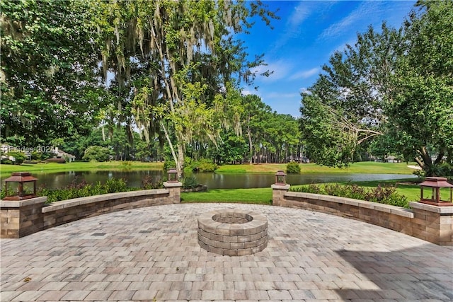 view of patio with a water view and a fire pit