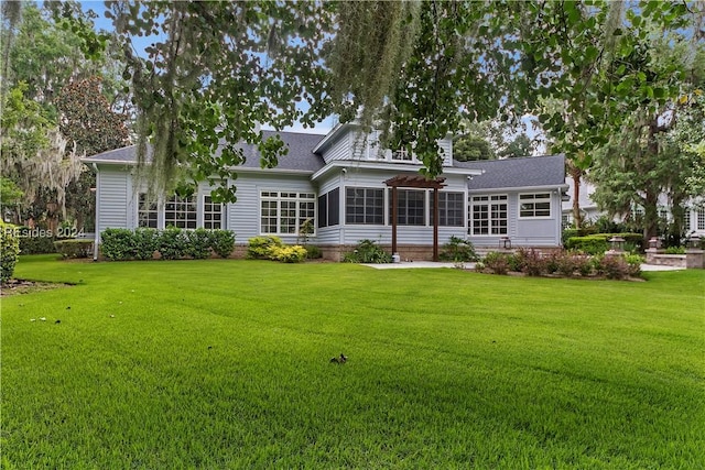 rear view of property with a sunroom and a lawn