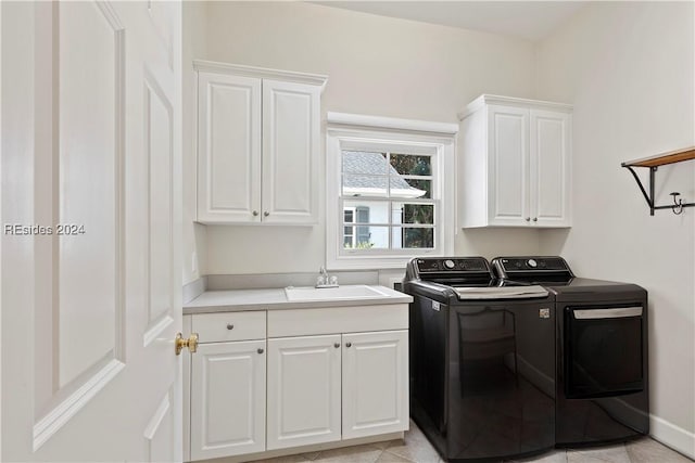 laundry area with sink, light tile patterned floors, washing machine and dryer, and cabinets