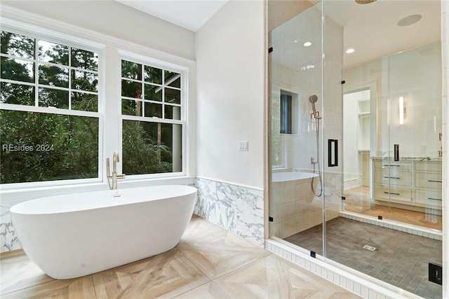 bathroom featuring parquet flooring, separate shower and tub, and tile walls