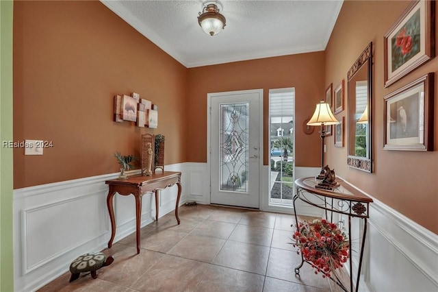 tiled entrance foyer featuring crown molding