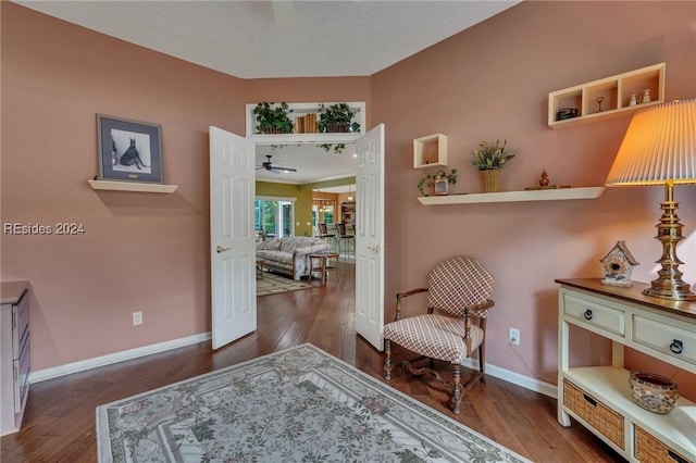 sitting room featuring dark hardwood / wood-style floors and a textured ceiling