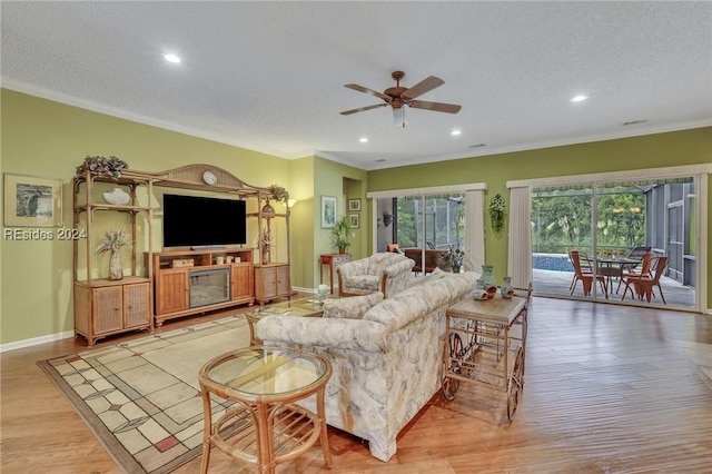 living room with crown molding, ceiling fan, a textured ceiling, and light wood-type flooring