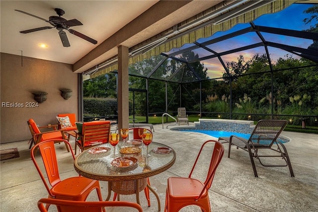 patio terrace at dusk featuring a lanai and ceiling fan