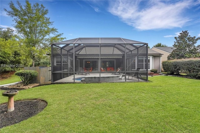 back of house featuring a patio, glass enclosure, and a lawn