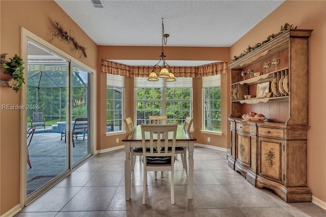 tiled dining room with a textured ceiling and a notable chandelier