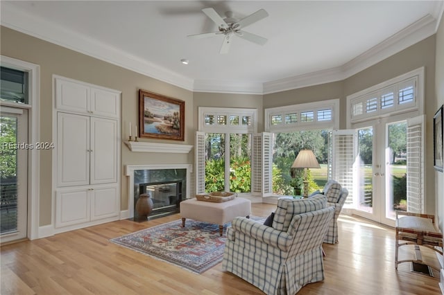 interior space featuring a high end fireplace, ornamental molding, french doors, and light wood-type flooring