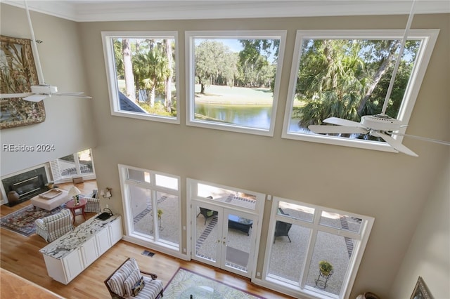 living room with a healthy amount of sunlight, ornamental molding, light hardwood / wood-style floors, and ceiling fan