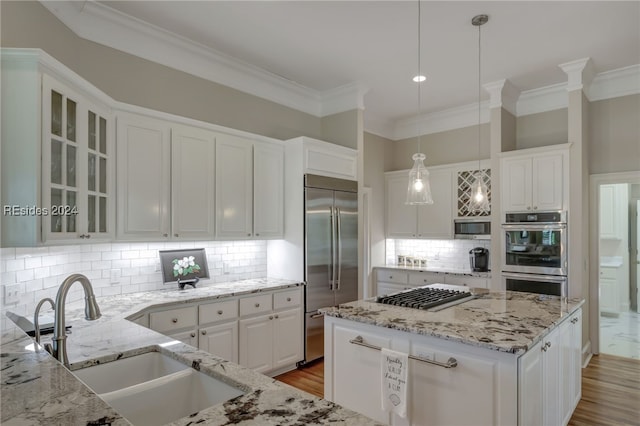 kitchen with pendant lighting, white cabinetry, and stainless steel appliances