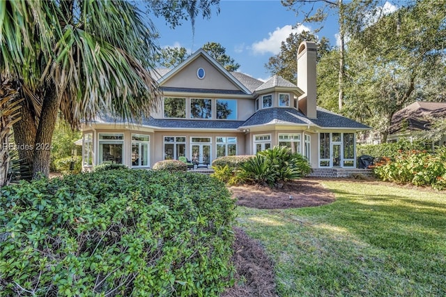 rear view of property featuring a lawn and french doors