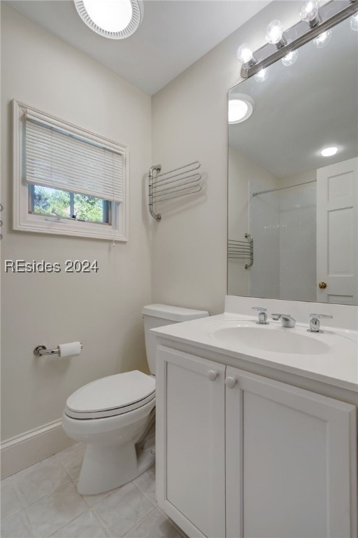 bathroom with tile patterned flooring, vanity, toilet, and walk in shower