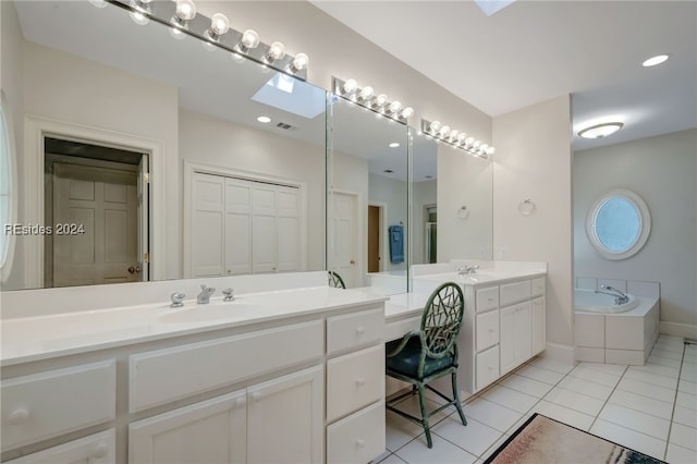 bathroom with vanity, a relaxing tiled tub, and tile patterned floors