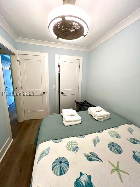 bedroom featuring ornamental molding and dark hardwood / wood-style flooring