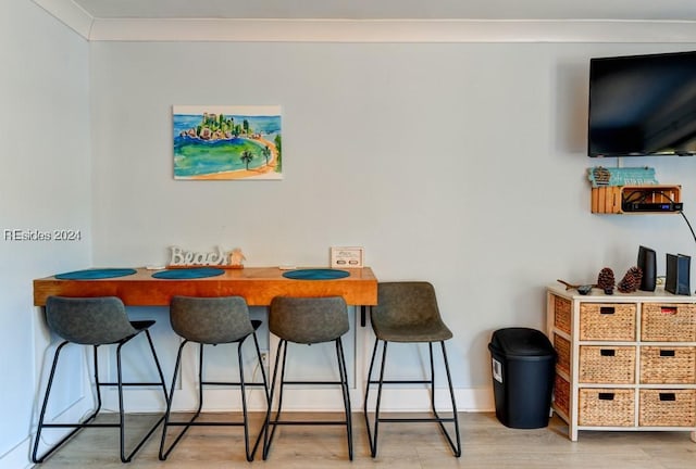 dining area featuring hardwood / wood-style flooring and ornamental molding