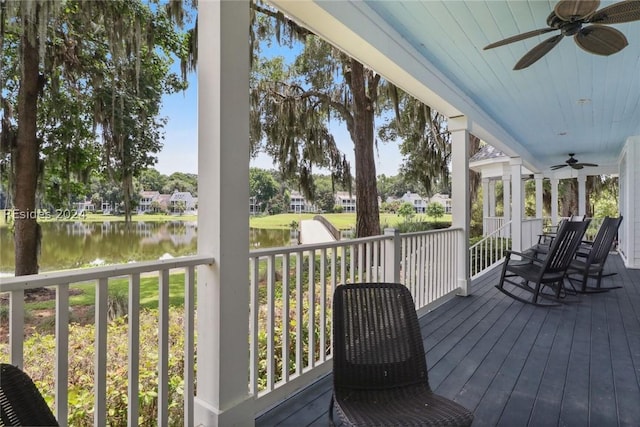 wooden deck featuring a water view and ceiling fan