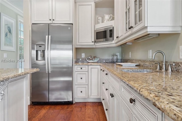 kitchen featuring white cabinetry, appliances with stainless steel finishes, sink, and light stone counters