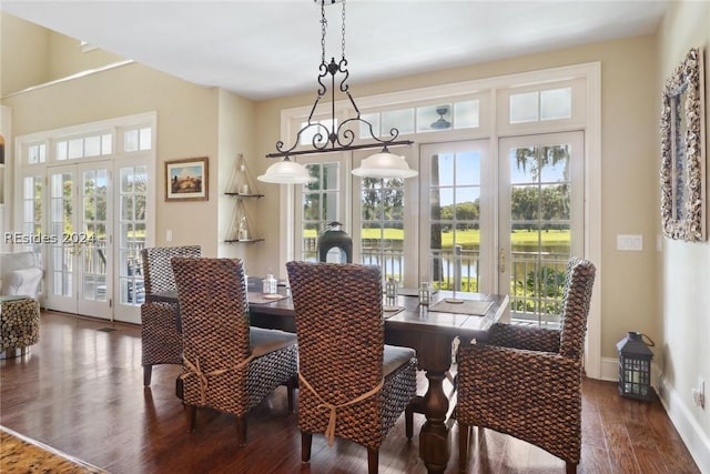 dining room with french doors, a water view, and dark wood-type flooring