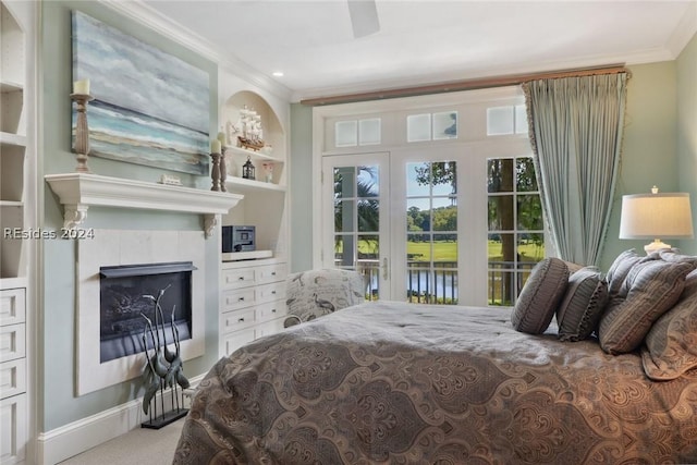 carpeted bedroom with a water view, access to outside, ornamental molding, ceiling fan, and a tiled fireplace