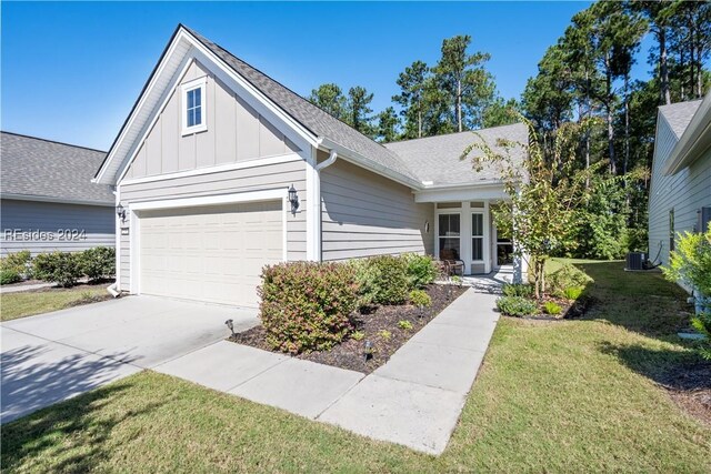 view of front facade with a garage, central AC, and a front yard