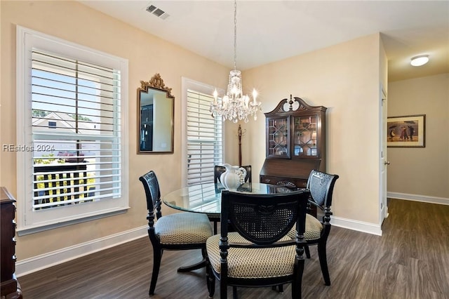 dining space featuring dark hardwood / wood-style floors, a wealth of natural light, and a notable chandelier