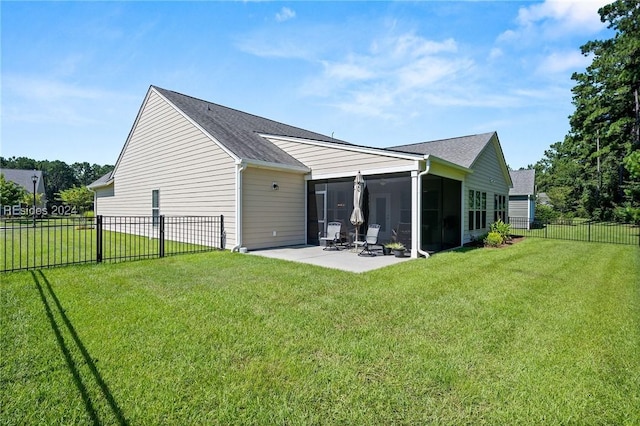 rear view of property with a yard, a patio area, and a sunroom