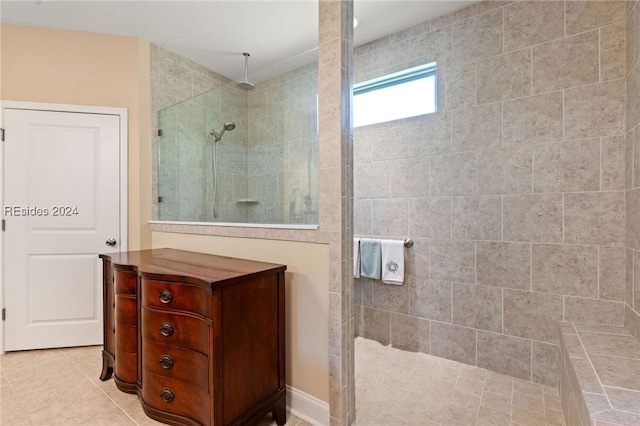 bathroom with a tile shower and tile patterned flooring