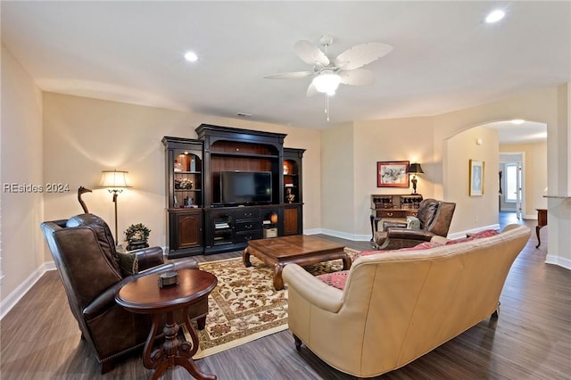 living room featuring dark wood-type flooring and ceiling fan