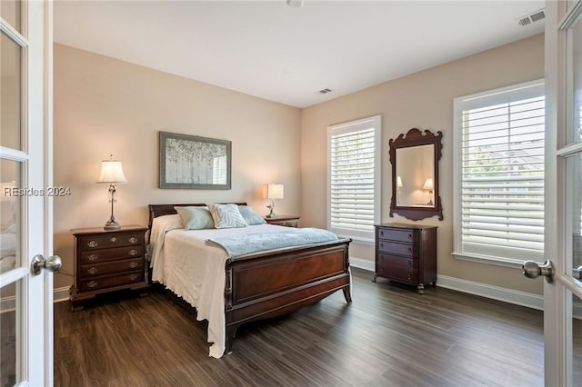 bedroom with dark hardwood / wood-style floors and french doors