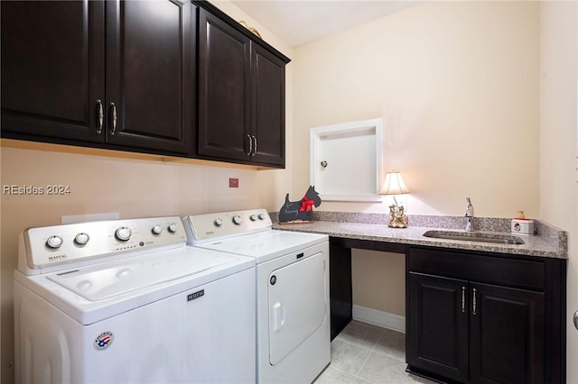 laundry area with sink, light tile patterned floors, washer and clothes dryer, and cabinets