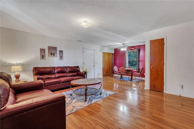 living room with a textured ceiling and light hardwood / wood-style floors