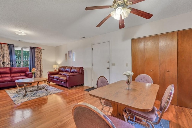 dining area with a textured ceiling and light wood-type flooring