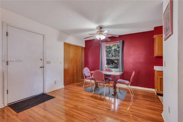 dining space featuring ceiling fan, light hardwood / wood-style floors, and a textured ceiling