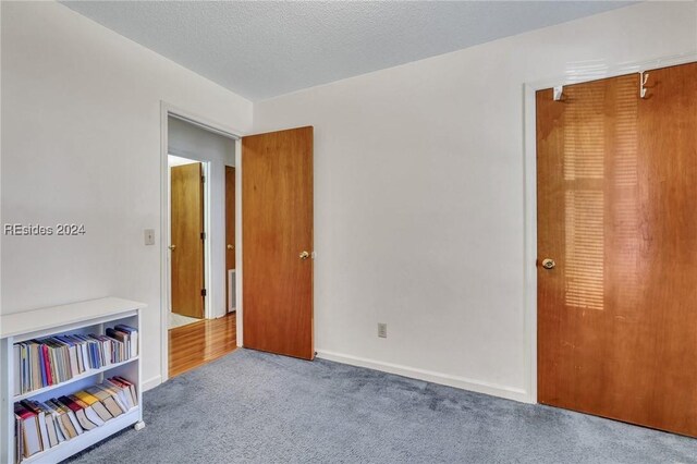 unfurnished bedroom with carpet flooring and a textured ceiling