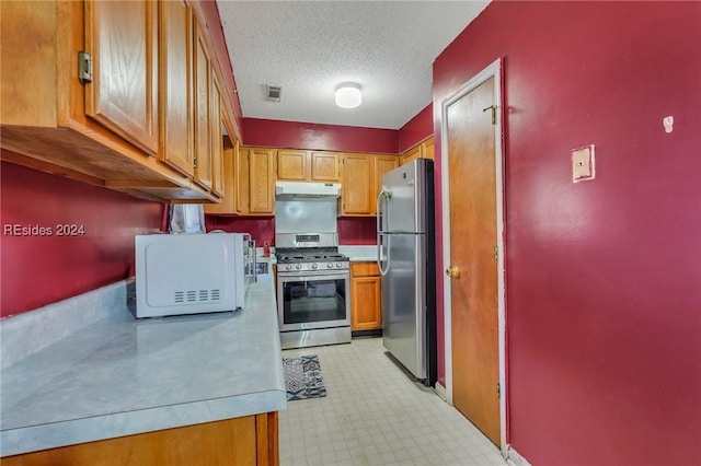 kitchen with appliances with stainless steel finishes and a textured ceiling