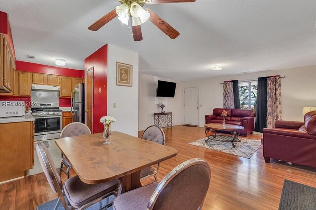 dining space featuring ceiling fan and light wood-type flooring