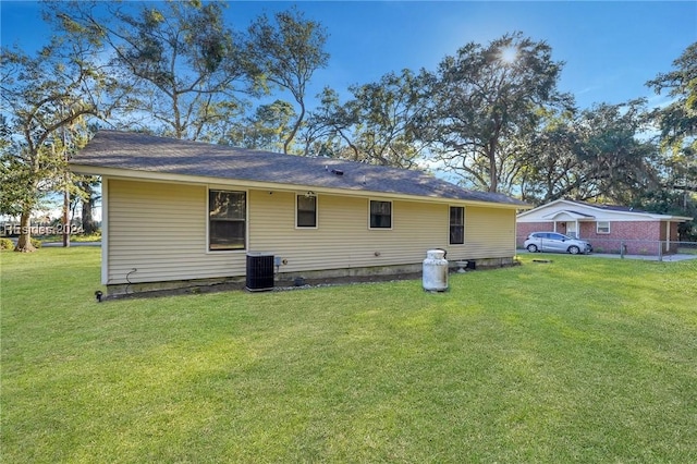 rear view of house featuring a yard and central AC