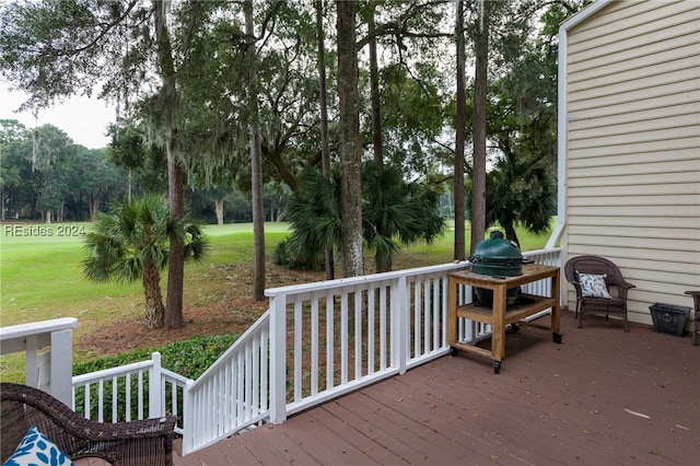 wooden deck featuring a lawn