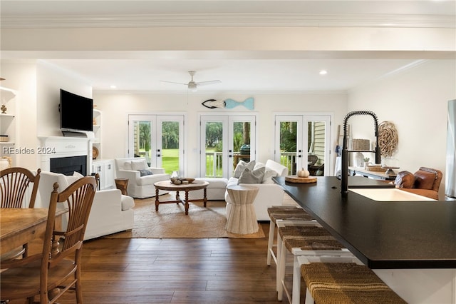 living room featuring crown molding, dark hardwood / wood-style floors, ceiling fan, and french doors