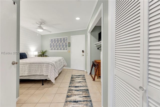 tiled bedroom featuring ceiling fan, ornamental molding, and a closet